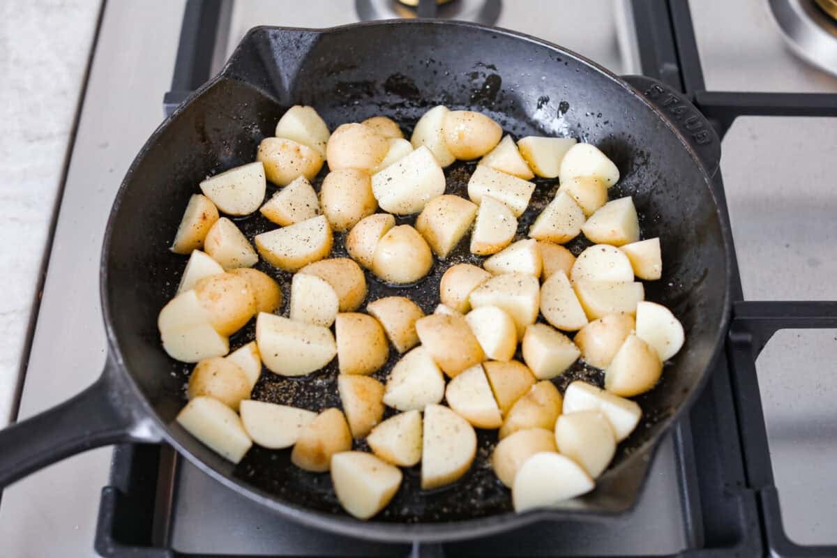 Get ready to obsess! These Garlic Butter Herb Steak Bites with Potatoes are juicy, buttery, and downright irresistible. Easy to make, crazy delicious, and pure comfort in every bite! Diced potatoes cooking in a skillet.