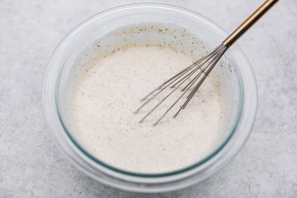 It’s like your favorite deli sub ditched the bread and got a glow-up. Think layers of crispy lettuce, your favorite meats, and a creamy dressing all in this yummy Grinder Salad form! Bowl of dressing ingredients whisked together.