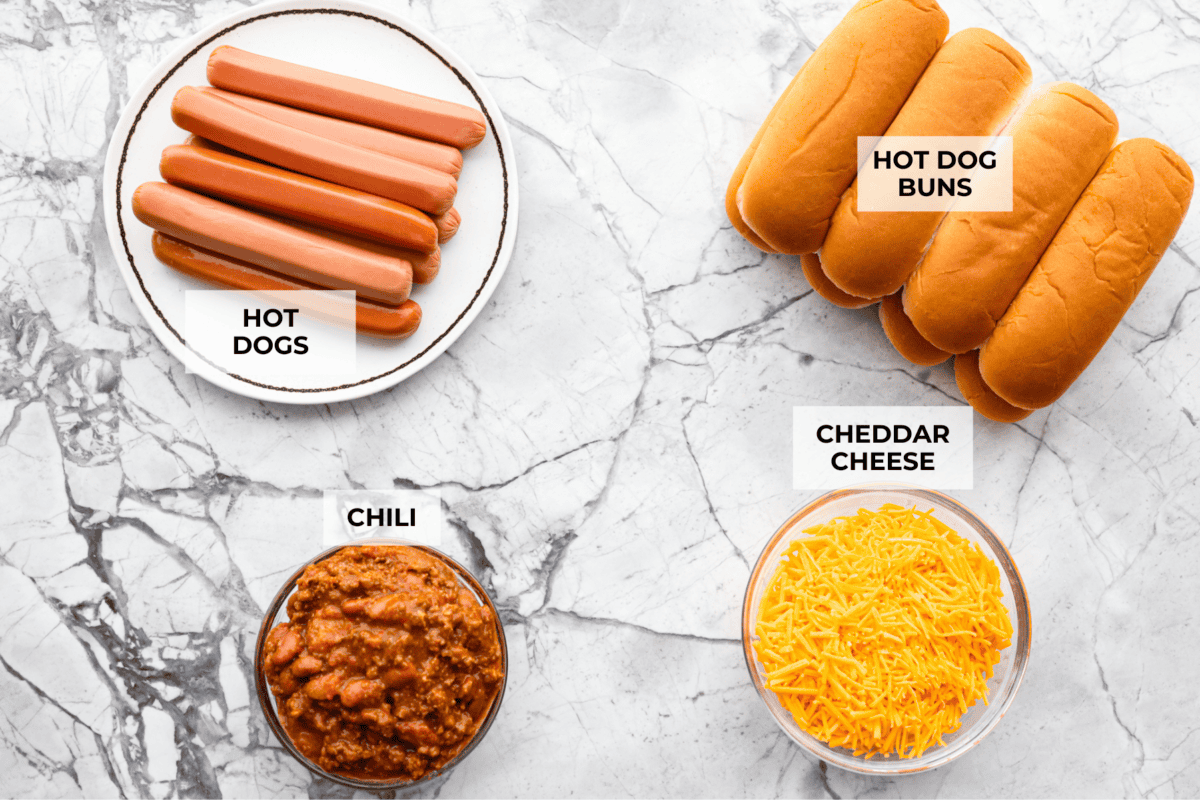 These Baked Chili Cheese Dogs are dangerously good. We’re talking soft buns, hearty chili, and ooey gooey cheese. They’re quick, messy (in the best way), and totally delicious! Overhead shot of labeled ingredients.