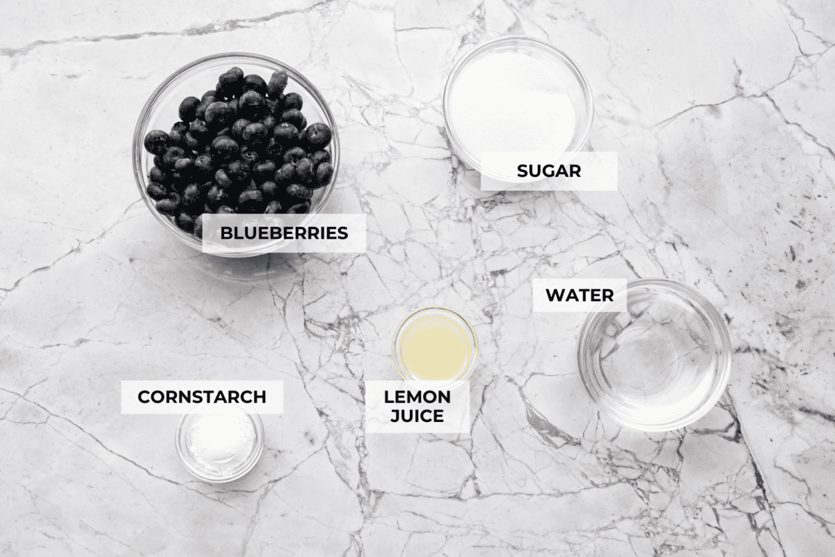 My homemade Blueberry syrup is next-level amazing! My secret ingredient? A splash of lemon! It’s the perfect balance to those sweet, juicy berries and makes your morning pancakes totally irresistible! Overhead shot of labeled ingredients.