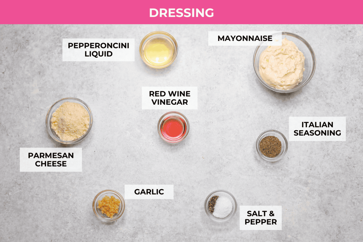 It’s like your favorite deli sub ditched the bread and got a glow-up. Think layers of crispy lettuce, your favorite meats, and a creamy dressing all in this yummy Grinder Salad form! Overhead shot of labeled dressing ingredients.