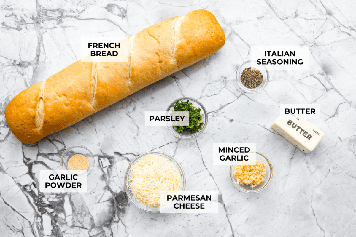 Iโm not saying Iโve eaten half a loaf of this Garlic Bread straight off the baking sheetโฆbut Iโm also not not saying that. Itโs golden, cheesy, dripping with garlicky butter, and so good! Overhead shot of labeled ingredients.
