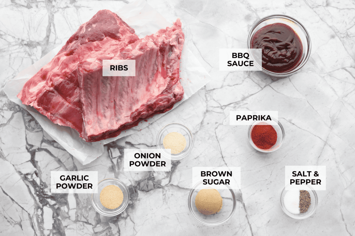 Myย Slow Cooker Ribsย are hands-down one of my favorite recipes on the site! They fall off the bone, are coated in sticky-sweet sauce, and are unbelievably easy to make. Overhead shot of labeled ingredients.