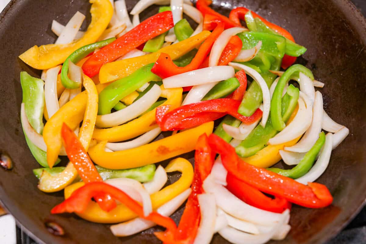 Apparently garlic fixes everything, and you knew it before I did. After a few of you suggested adding it to this Italian Sausage & Peppers, I gave it a tryโฆ and wow! Turns out, garlic takes this from good to seriously addictive. Vegetables cooking in a skillet.