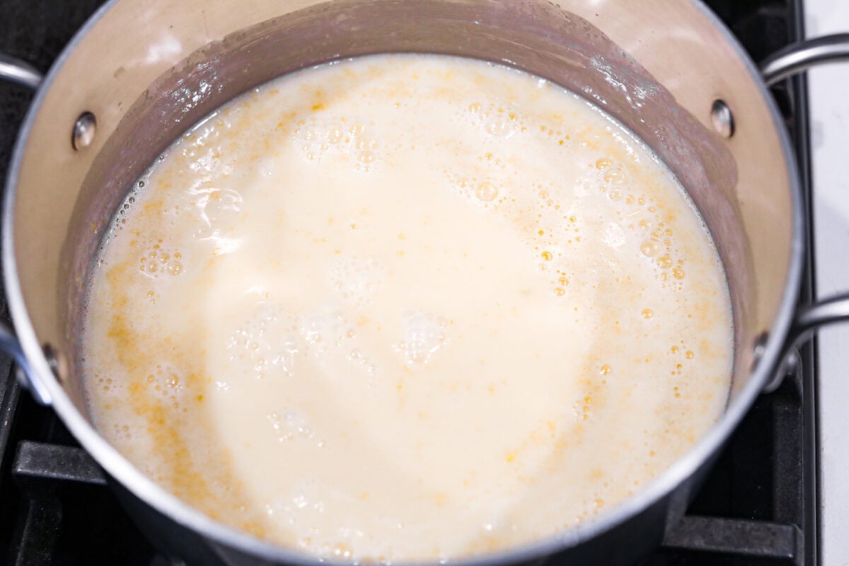 Lemon Posset- Only 5 Ingredients! The ingredients simmering in a pot on the stove.