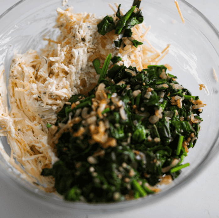 Do you love spinach dip as much as I do? My Spinach Stuffed Chicken Breast turns those creamy, cheesy flavors into an insanely delicious dinner. Quick, easy, and seriously so good. Cream cheese mixture with spinach mixture in a bowl.