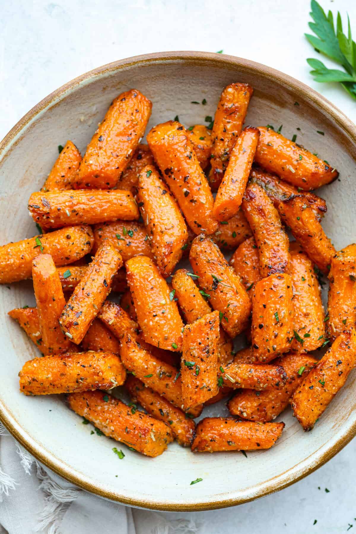 If there’s one side dish that never sticks around for long at my house, it’s these air fryer carrots! They’re crisp on the outside, tender inside, and seasoned to bring out all their natural sweetness—even the picky eaters love them! A plate of cooked garlic carrots.