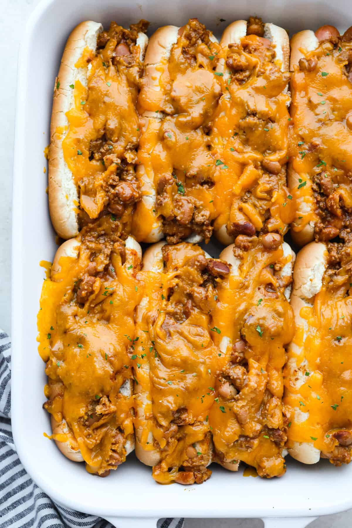 Overhead shot of baked chili cheese dogs.