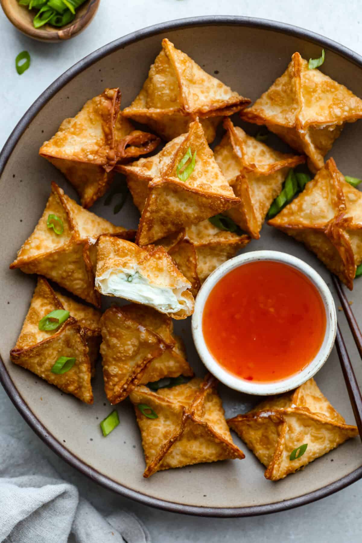 If you guys are as obsessed with cream cheese wontons as I am, you are going to love this easy-to-follow recipe! These crispy, creamy, wontons are totally doable! Plate of crispy cream cheese wontons.