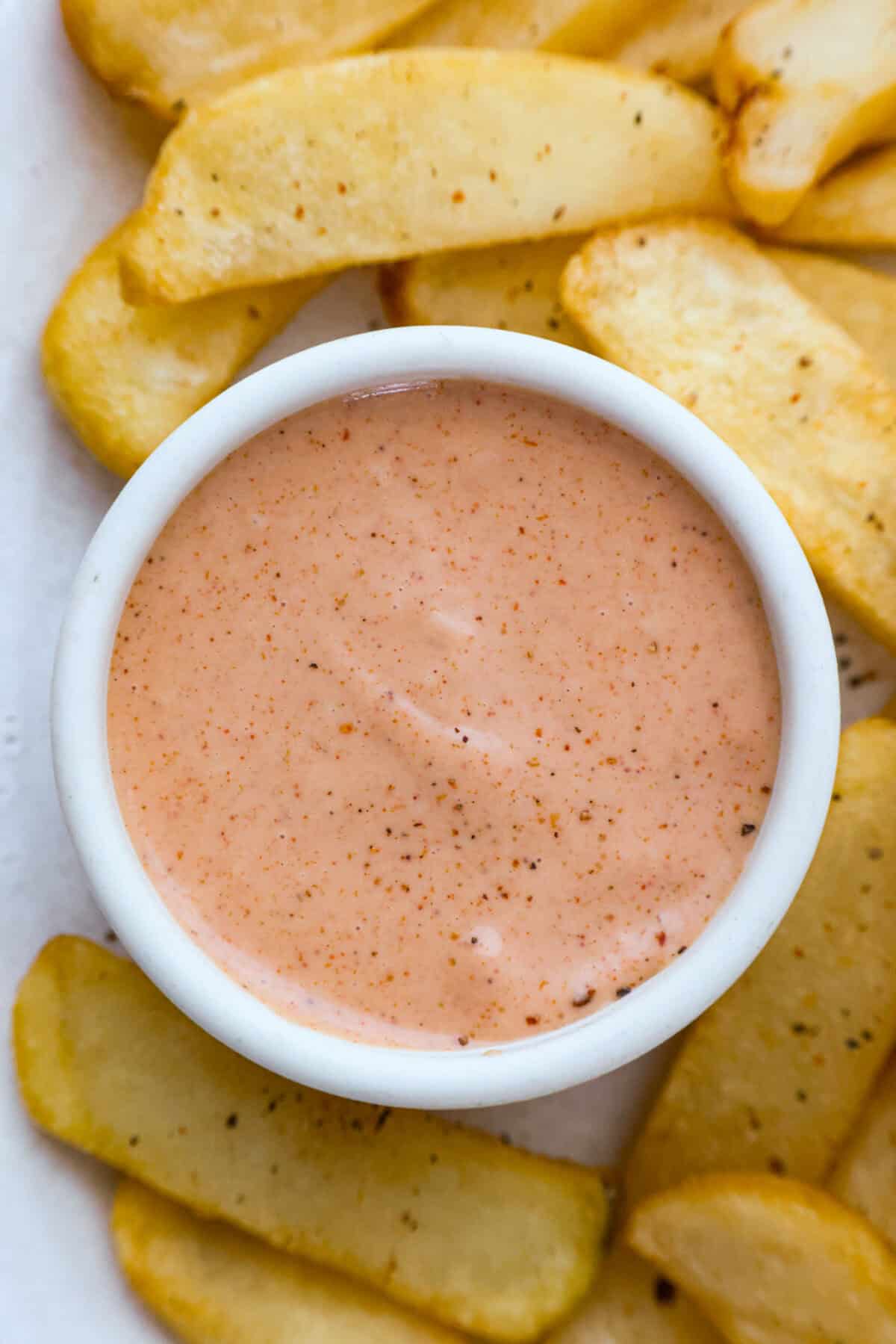 Born and raised in Utah—the true home of fry sauce—I’ve perfected this recipe to pair with just about everything. This isn’t your average ketchup-mayo mix. The secret ingredient? Pickle Brine. Stay with me! It brings the BEST tang to the sauce!! Overhead shot of a small bowl of fry sauce surrounded by french fries.