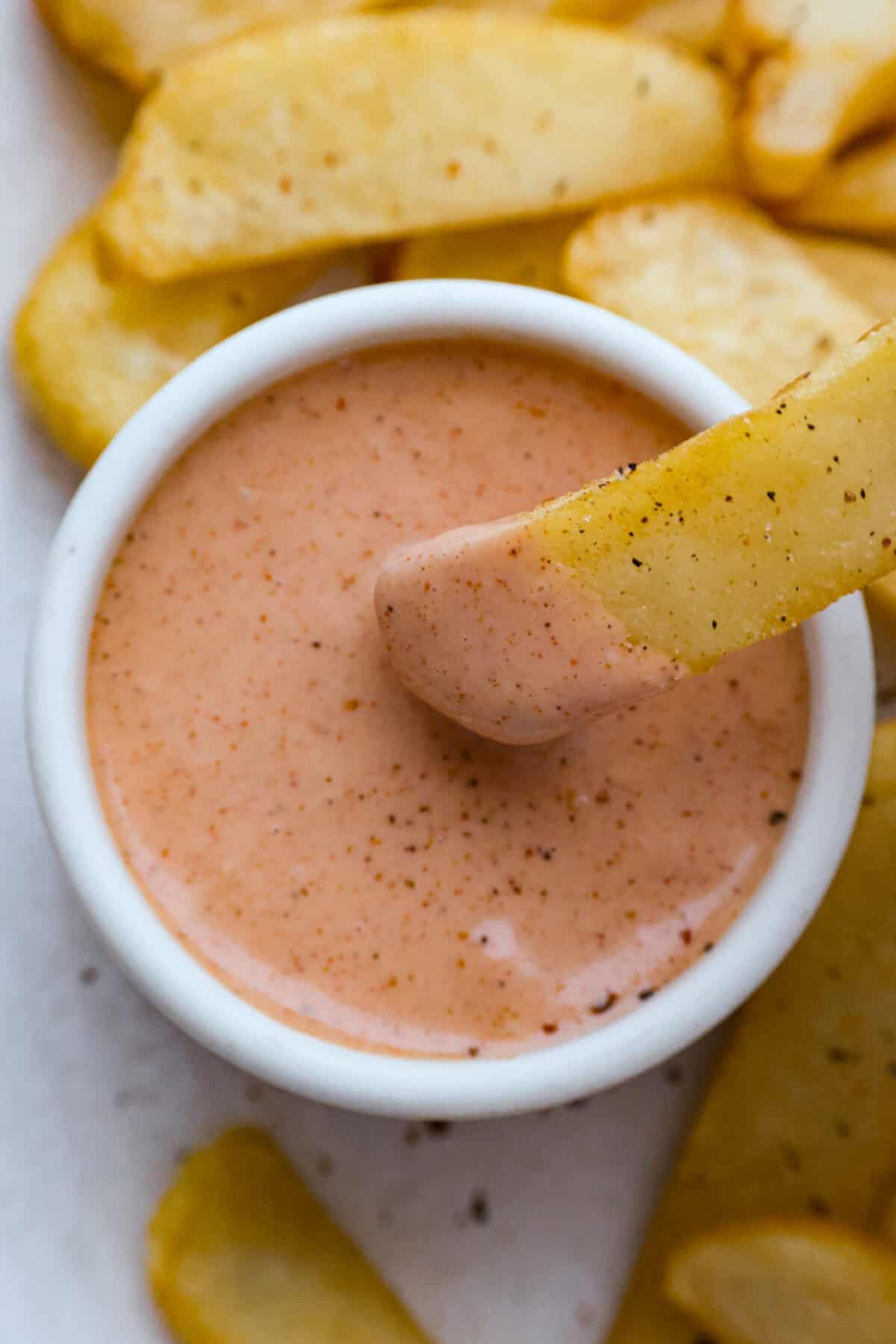 Born and raised in Utah—the true home of fry sauce—I’ve perfected this recipe to pair with just about everything. This isn’t your average ketchup-mayo mix. The secret ingredient? Pickle Brine. Stay with me! It brings the BEST tang to the sauce!! Someone dipping a fry into the fry sauce.