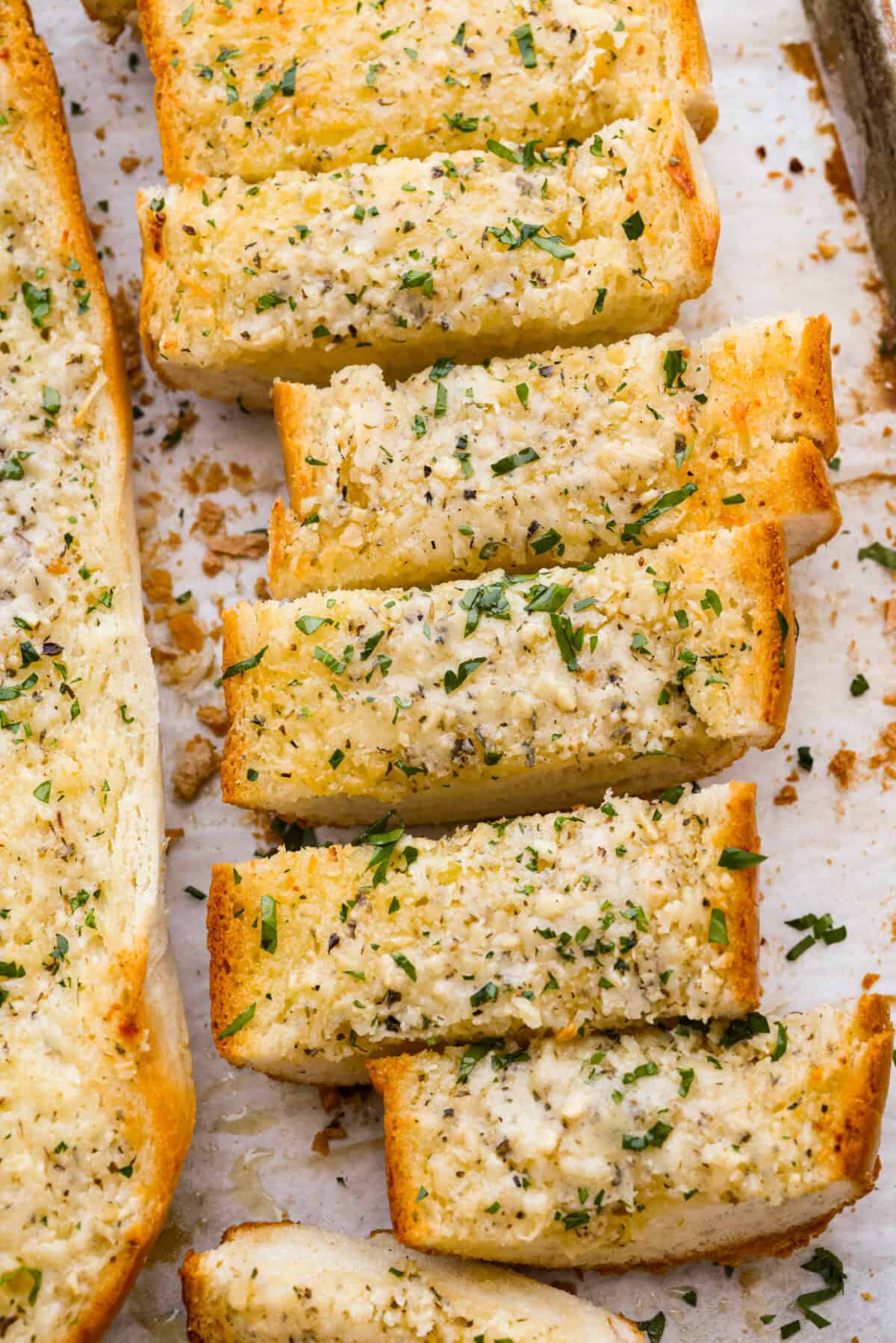 Iโm not saying Iโve eaten half a loaf of this Garlic Bread straight off the baking sheetโฆbut Iโm also not not saying that. Itโs golden, cheesy, dripping with garlicky butter, and so good! Slice up browned garlic bread.