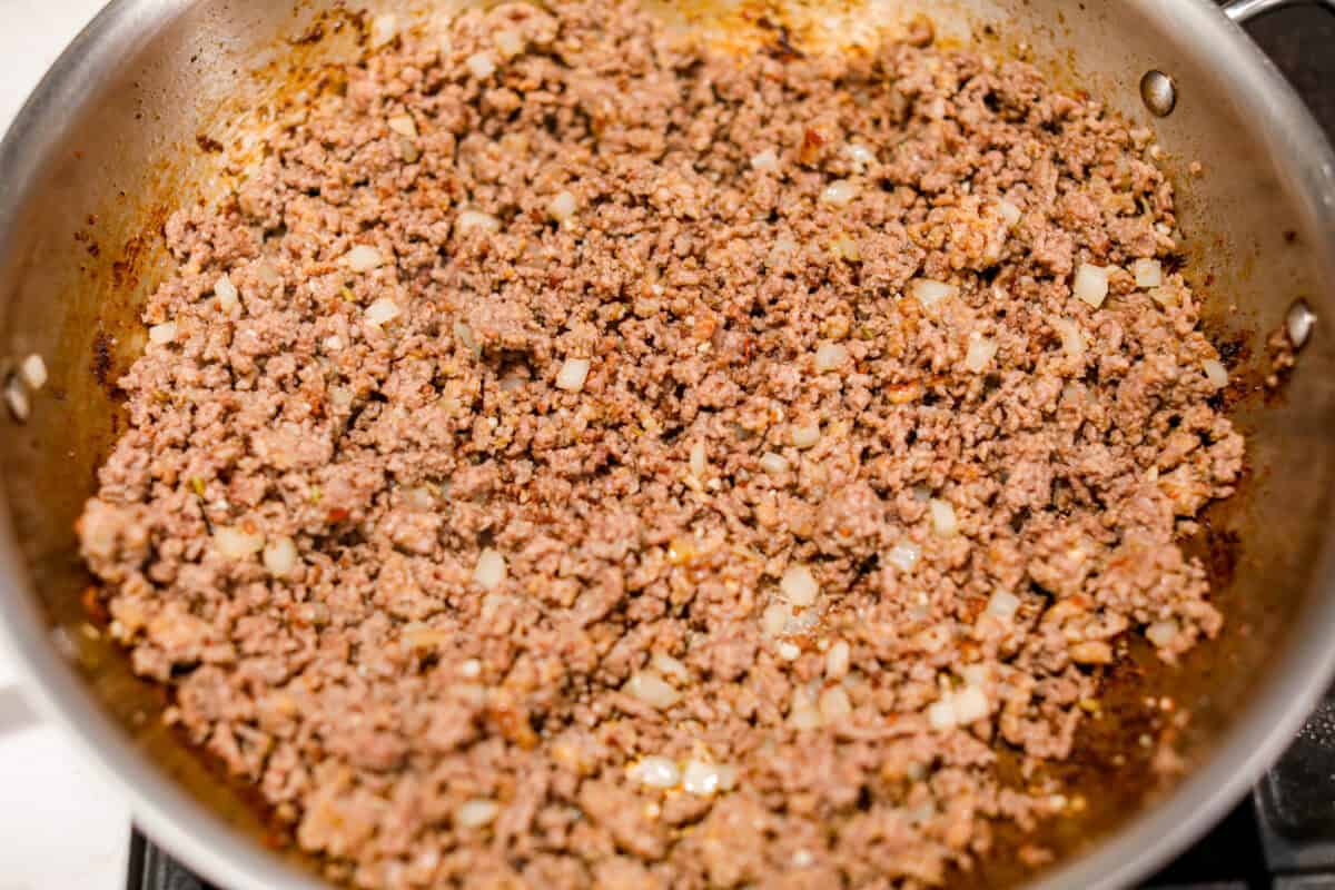 Million Dollar Spaghetti takes baked spaghetti to a whole new level. That cheesy, cream cheese, sour cream, and ricotta layer makes it so dreamy! One bite and you’ll ask, “Wait... why have I not been making spaghetti like this my whole life?” Meats cooking in a skillet with added garlic and onion.