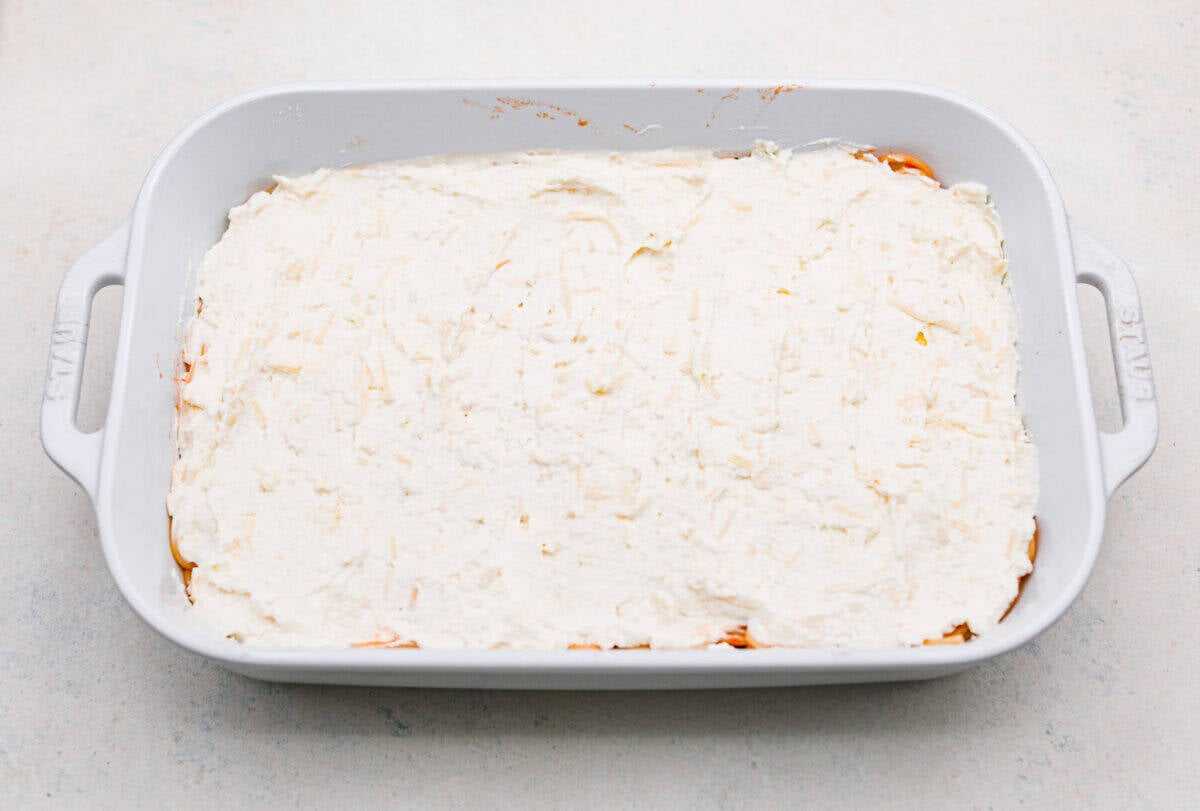 Million Dollar Spaghetti takes baked spaghetti to a whole new level. That cheesy, cream cheese, sour cream, and ricotta layer makes it so dreamy! One bite and you’ll ask, “Wait... why have I not been making spaghetti like this my whole life?” Million dollar spaghetti cheese layer spread over the top of the butter and noodles.