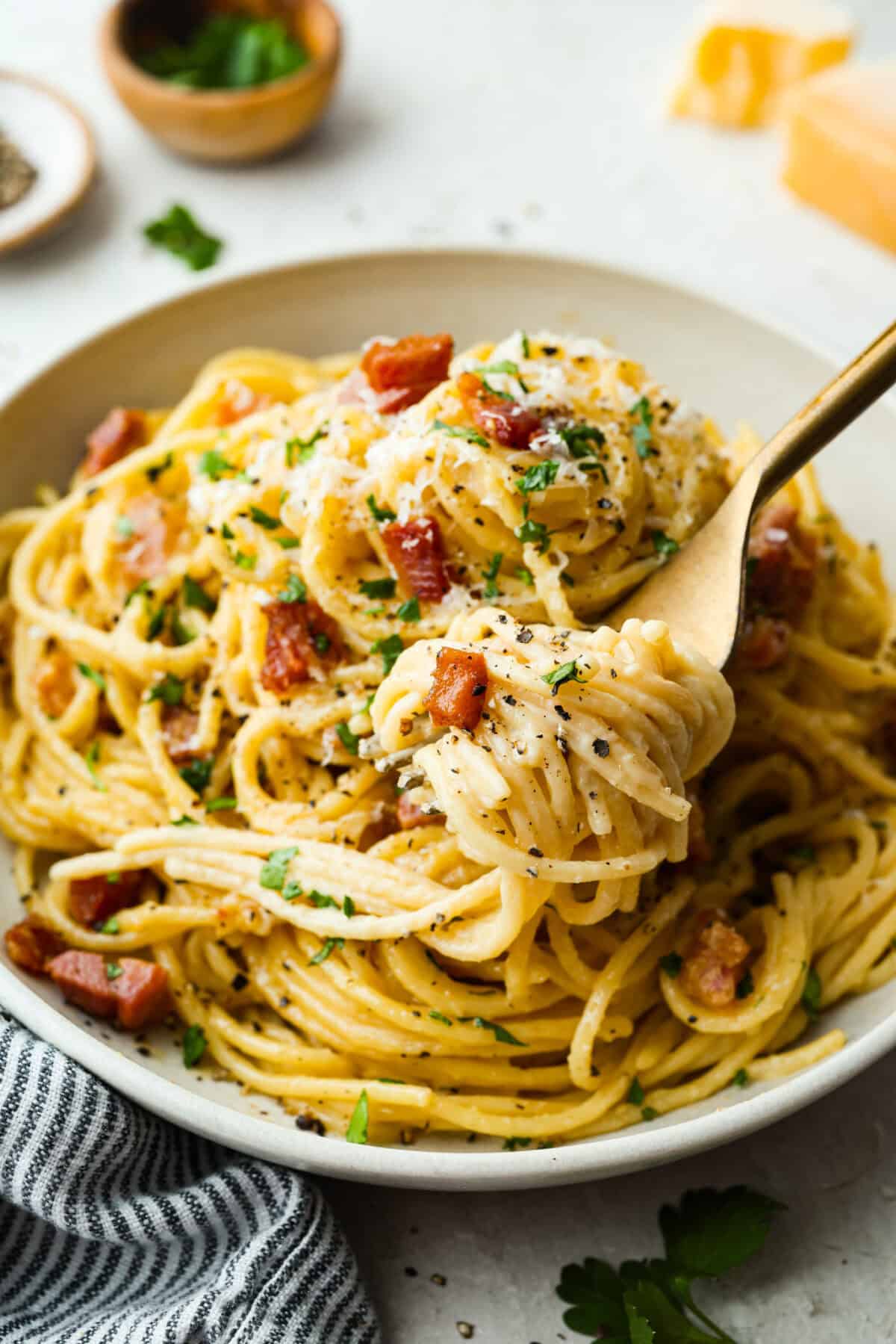 You guys! My pasta carbonara is the real deal—creamy, dreamy, and so full of flavor! Just eggs, cheese, pancetta, and pasta magic. It feels restaurant worthy but takes less than 30 minutes! A forkful of pasta carbonara over the plated dish.