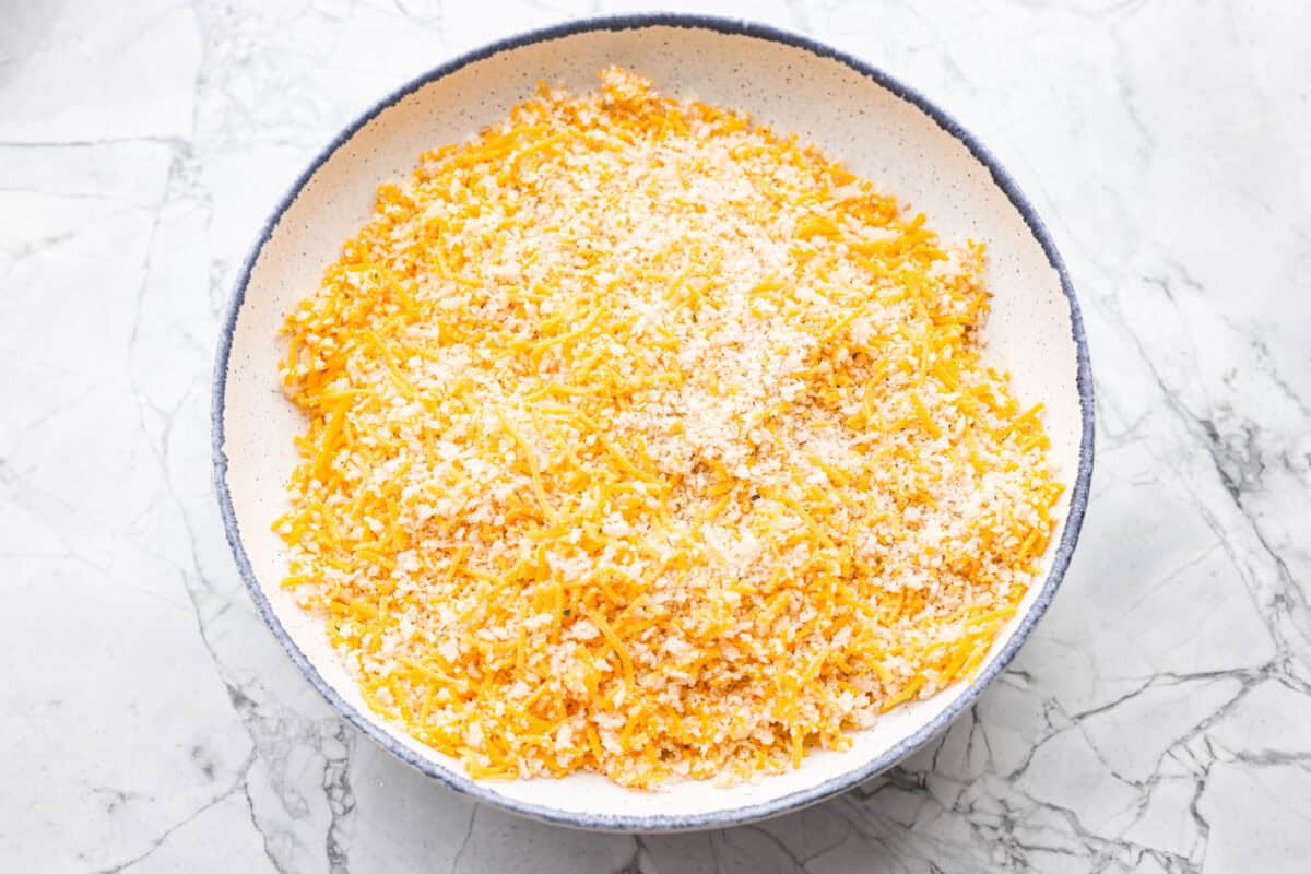 If you're looking for a tasty spin on pork chops, this is it! The crispy, cheesy texture -ย don't even get me started! YUM! Add in some roasted veggies, and you have the best Sheet Pan Crispy Pork Chops dinner! Panko breadcrumbs, cheddar cheese and seasonings all mixed together in a shallow dish.