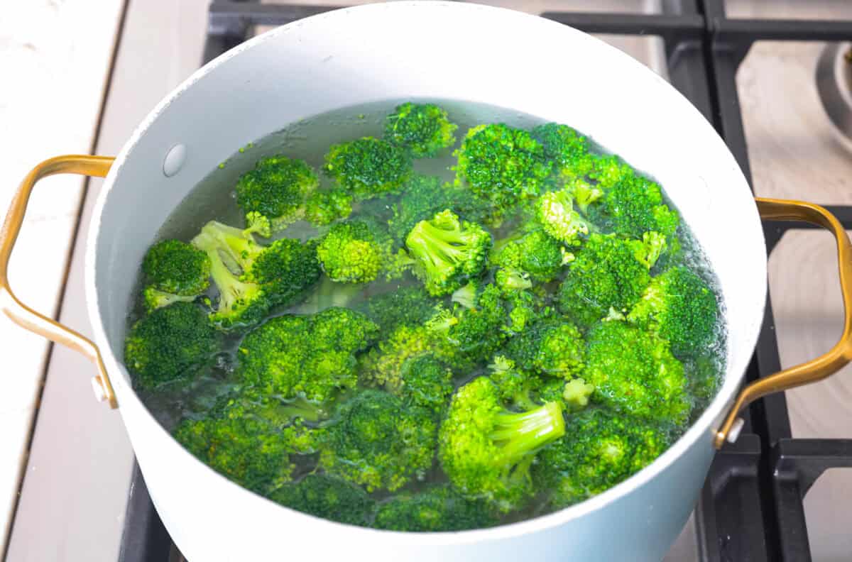 Skillet Sesame Chicken & Broccoli is your new favorite weeknight winner! With sweet and savory flavors in every bite, this easy stir-fry comes together in just 30 minutes. Broccoli in boiling water in a pot on the stove.