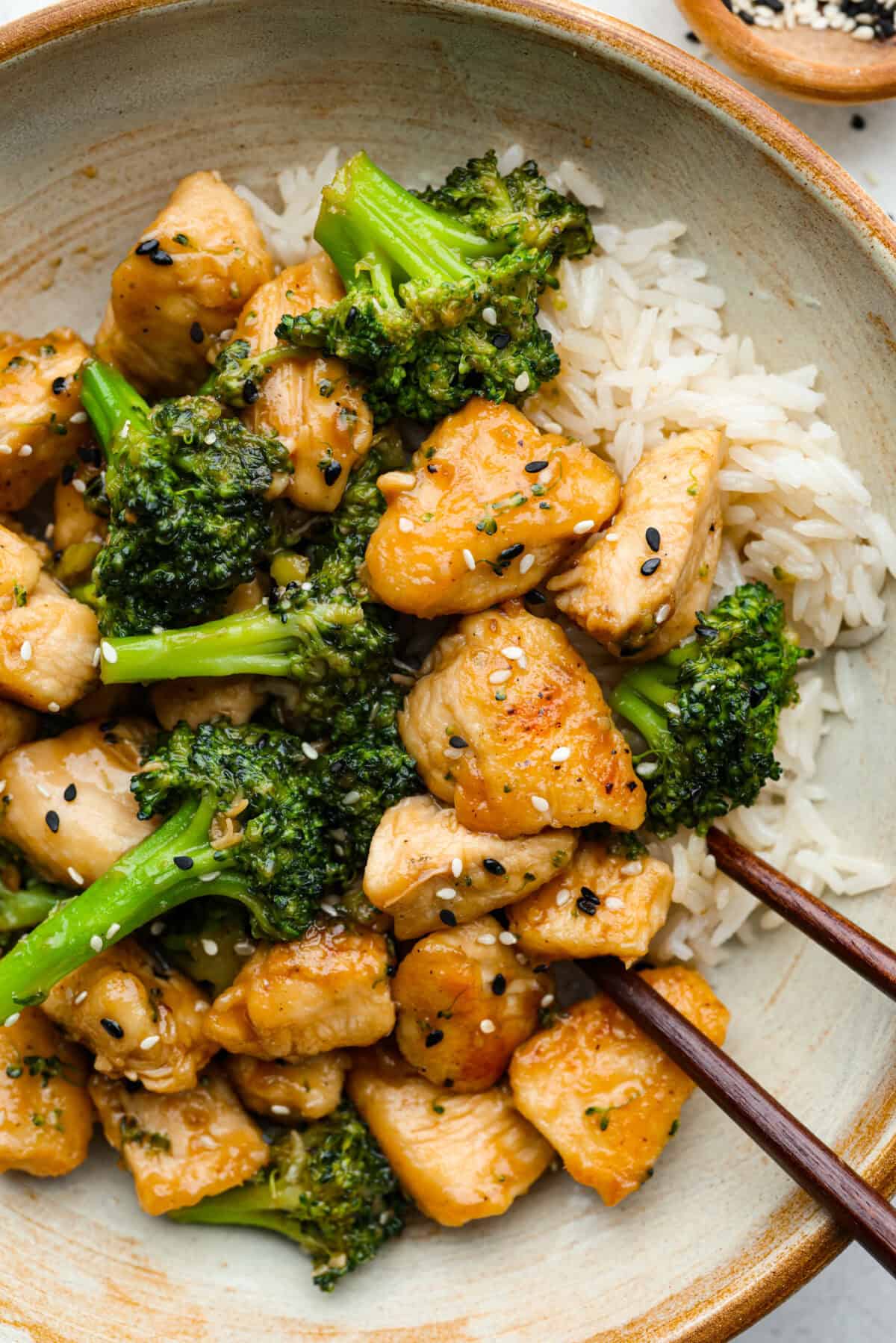 Skillet Sesame Chicken & Broccoli is your new favorite weeknight winner! With sweet and savory flavors in every bite, this easy stir-fry comes together in just 30 minutes. Plated sesame chicken and broccoli with chopsticks.