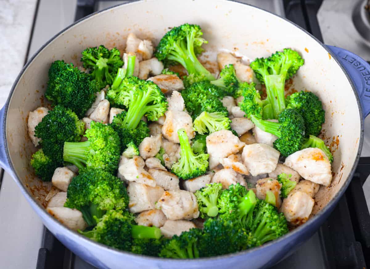 Skillet Sesame Chicken & Broccoli is your new favorite weeknight winner! With sweet and savory flavors in every bite, this easy stir-fry comes together in just 30 minutes. Close up of chicken and broccoli cooking together on the stove.