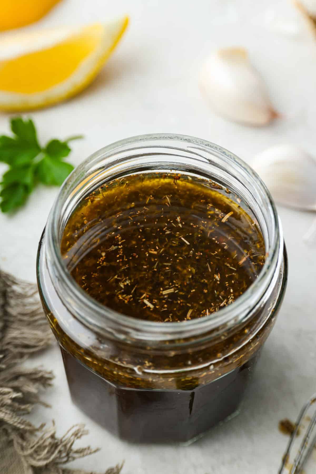 This steak marinade is one of the top recipes on my site! Itโs my go-to for turning tough, budget-friendly cuts into juicy, flavor-packed steaks that practically melt in your mouth. Angle shot of a glass jar with steak marinade inside.