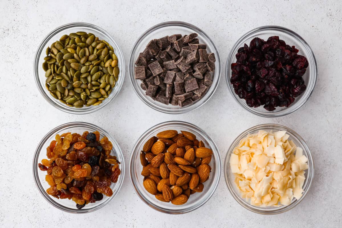 Trail mix is my go-to snack for busy days, road trips, or tossing in the kids' lunchboxes. Packed with flavor and endless mix-ins, trail mix is the perfect snack for any time! Different ideas for mix-ins in small bowls.