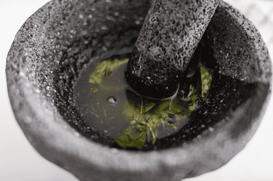 My Virgin Mojito is like a vacation in a glass. Crisp, minty, and packed with fresh lime flavor. This non-alcoholic drink is something my whole family loves! Overhead shot of someone muddling lime juice with mint leaves.