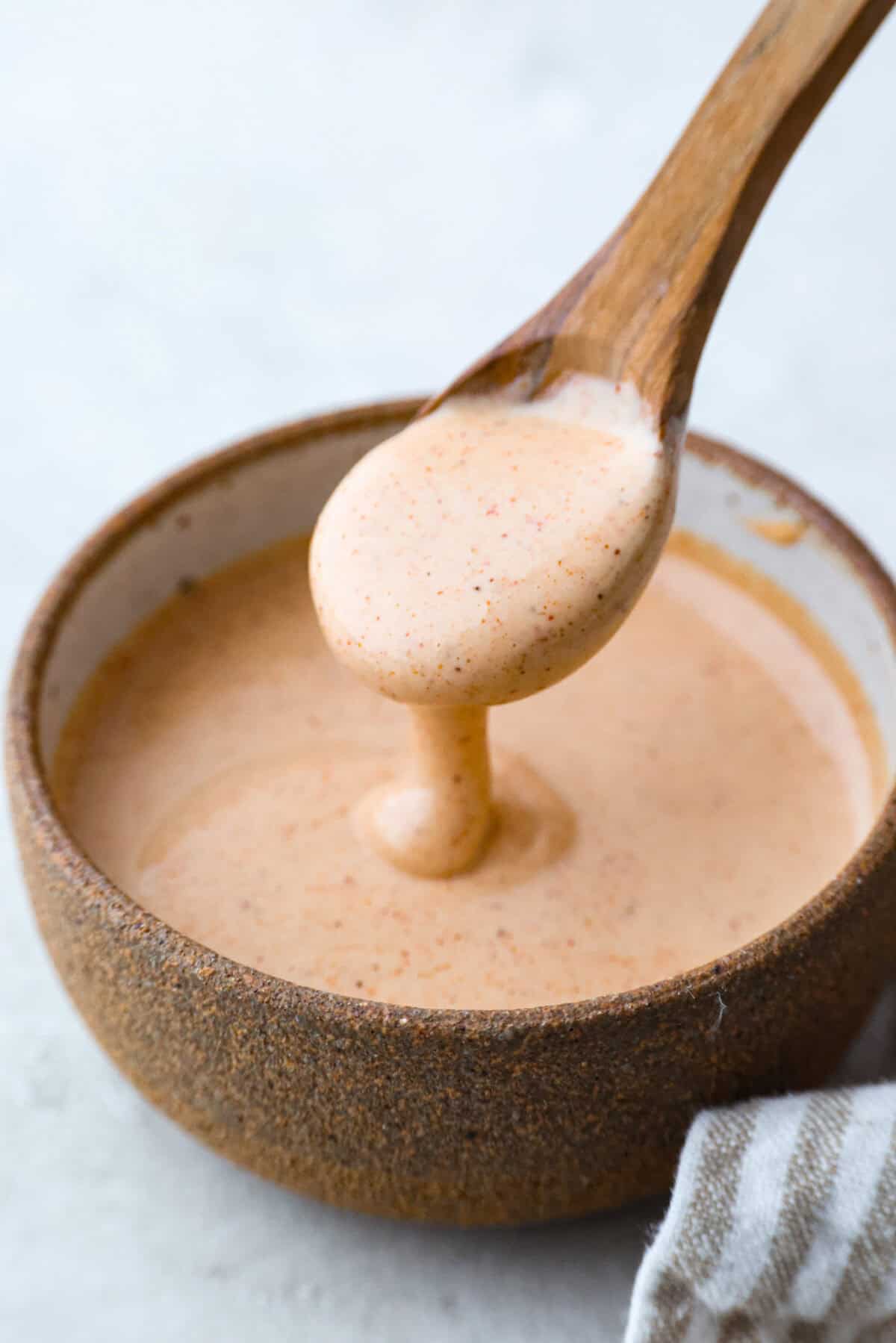 Why You Need Yum Yum Sauce In Your Life! Someone lifting a spoonful of yum yum sauce out of the bowl.