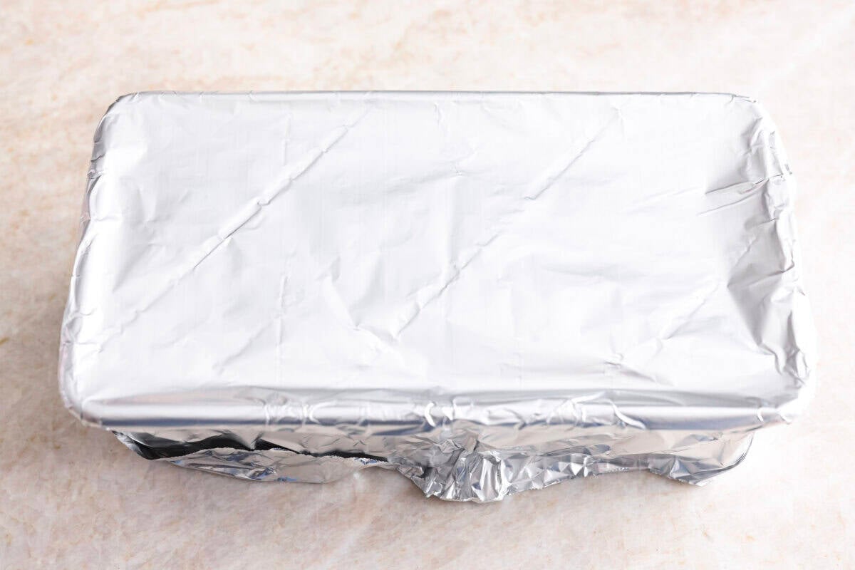 My easy-to-make gyro meat is perfectly seasoned and tender every time! Just like your favorite Mediterranean restaurant. Perfect for pitas, bowls, or platters with all your favorite toppings. Loaf pan covered in tin foil ready to be baked.