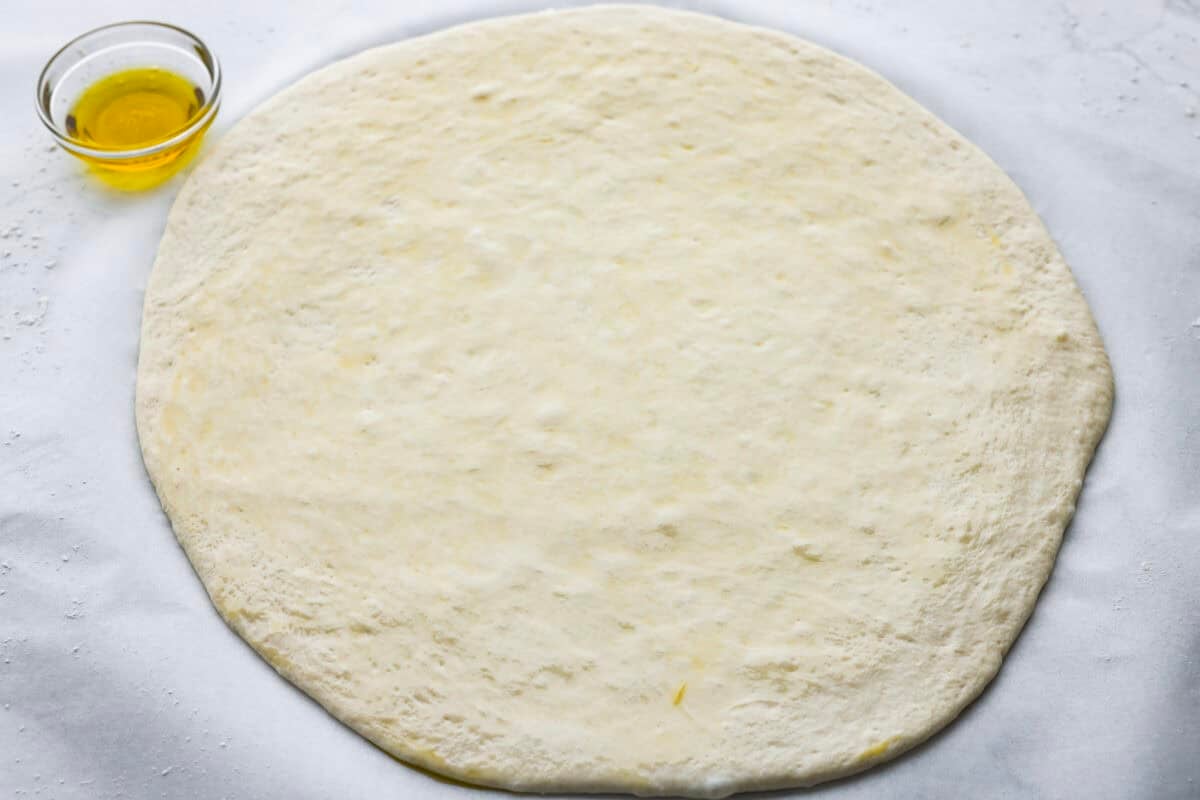 Iโm all about pizza and grilling, so when I can combine the two, itโs a win. The grill gives pizza that smoky, crispy flavor you canโt get from the oven. Trust me, this grilled pizza will have you hooked! Pizza dough rolled out into a circle.