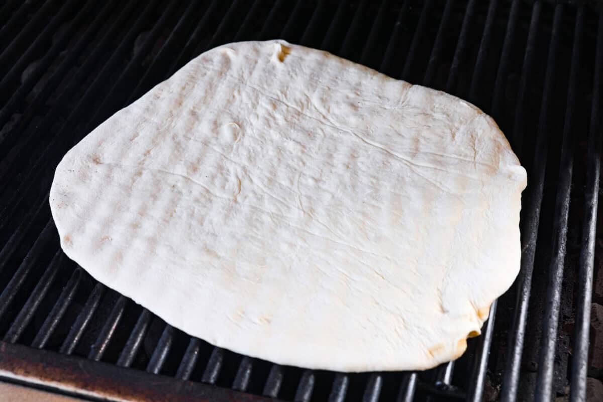 Iโm all about pizza and grilling, so when I can combine the two, itโs a win. The grill gives pizza that smoky, crispy flavor you canโt get from the oven. Trust me, this grilled pizza will have you hooked! Pizza dough on the grill.