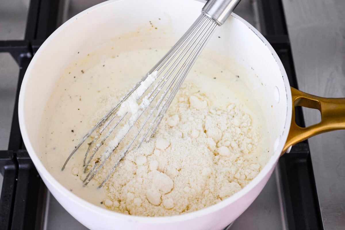 When I see Chicken Alfredo on a menu, I breathe a sigh of relief because I know my kids will actually eat it. I made this Chicken Alfredo Bake thatโs creamy, comforting, and ready in under 40 minutes. Someone whisking the cheese into the sauce.