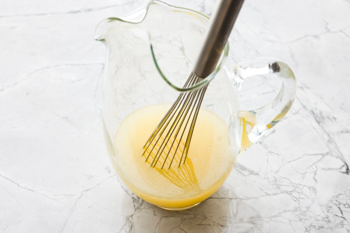 If you love iced tea, youโre going to be obsessed with this Arnold Palmer. The combo of crisp black tea and tangy lemonade is pure summer magic. Itโs simple, refreshing, and always just what you need. Someone stilling lemon juice and sugar in a large pitcher.