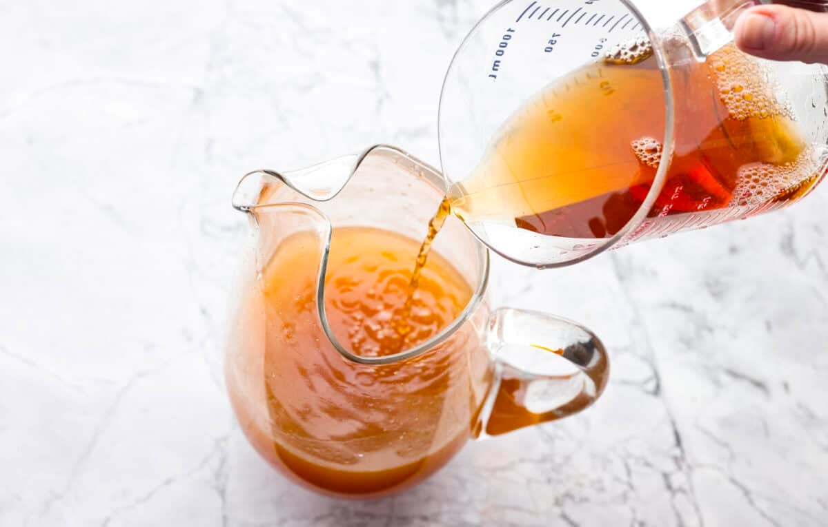 If you love iced tea, youโre going to be obsessed with this Arnold Palmer. The combo of crisp black tea and tangy lemonade is pure summer magic. Itโs simple, refreshing, and always just what you need. Someone pouring unsweetened black tea into the pitcher with lemon juice and sugar.