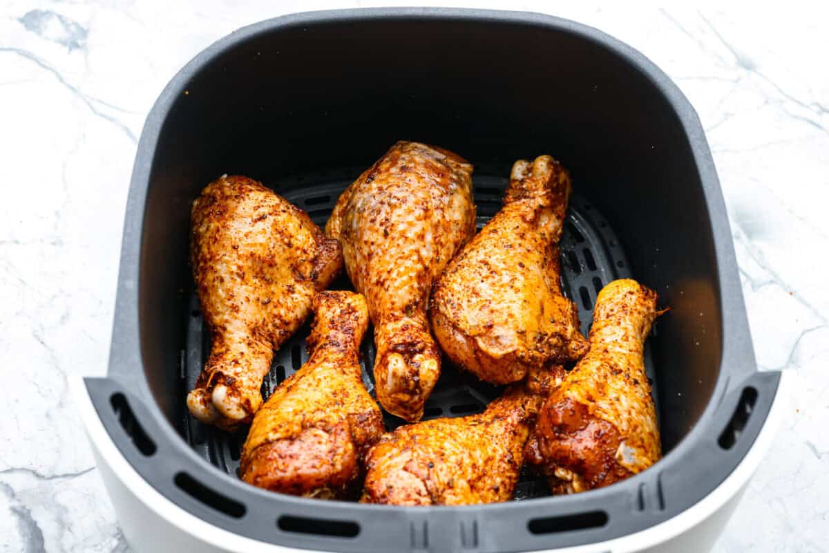My kids always fight over who gets the chicken legs. With this Air Fryer Chicken Legs recipe, I can whip up a few batches and keep everyone happy! The bold flavor and crispy air-fried skin are totally unbeatable. Seasoned chicken legs in the air fryer basket.
