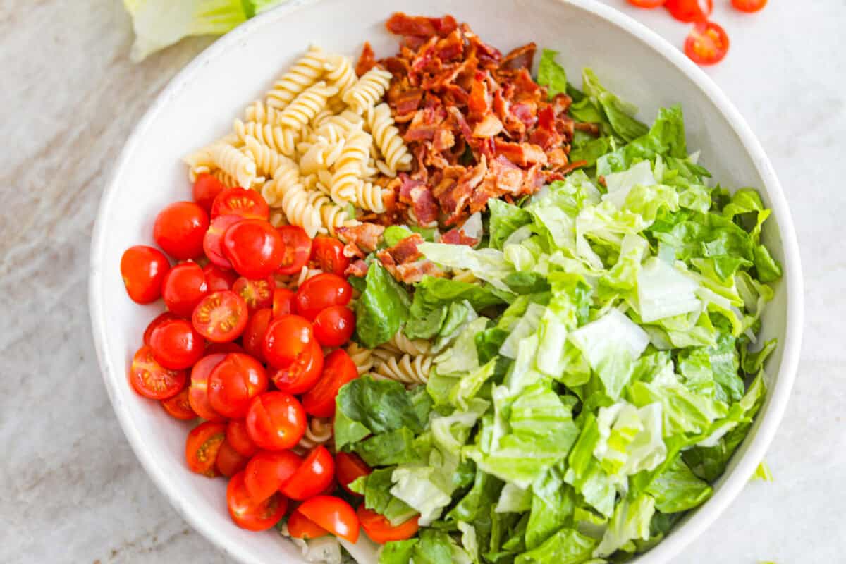 The best sandwich ever? Hands down, a BLT. Add in my obsession with pasta salads and, chefโs kiss! This BLT Pasta Salad has the crispy bacon, juicy tomatoes, and crunchy lettuce we all love! Bowl with pasta, lettuce, bacon, and tomatoes.