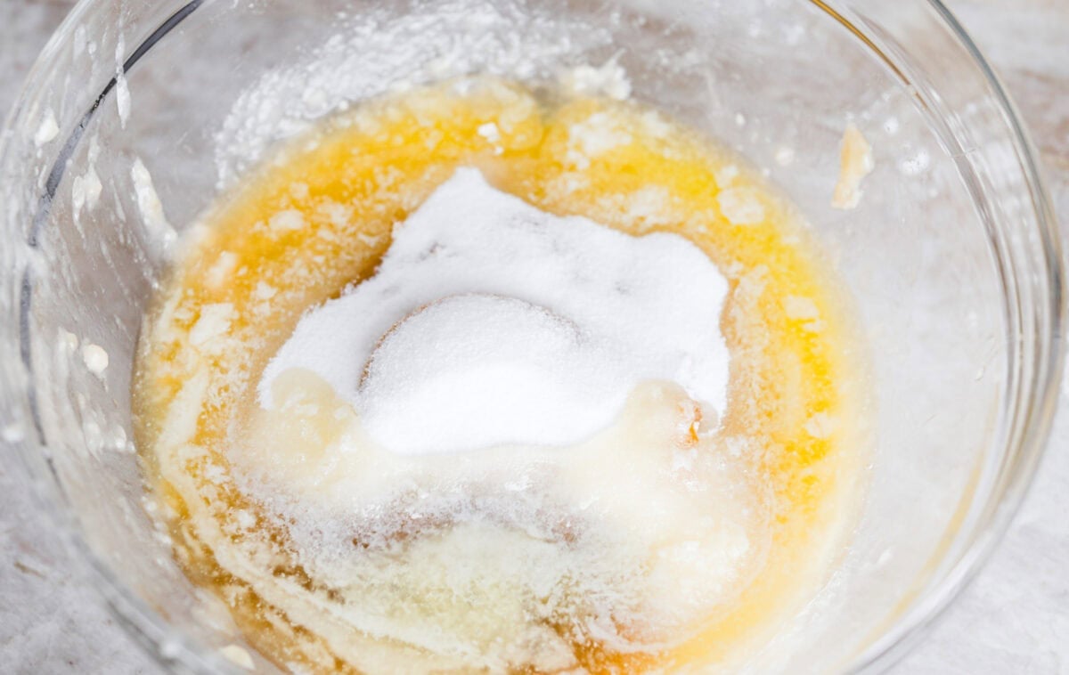 When my bananas start to turn brown and the kids need something quick, these banana muffins always save the day. They’re soft, sweet, and come together fast. Overhead shot of a bowl with wet ingredients and sugar.