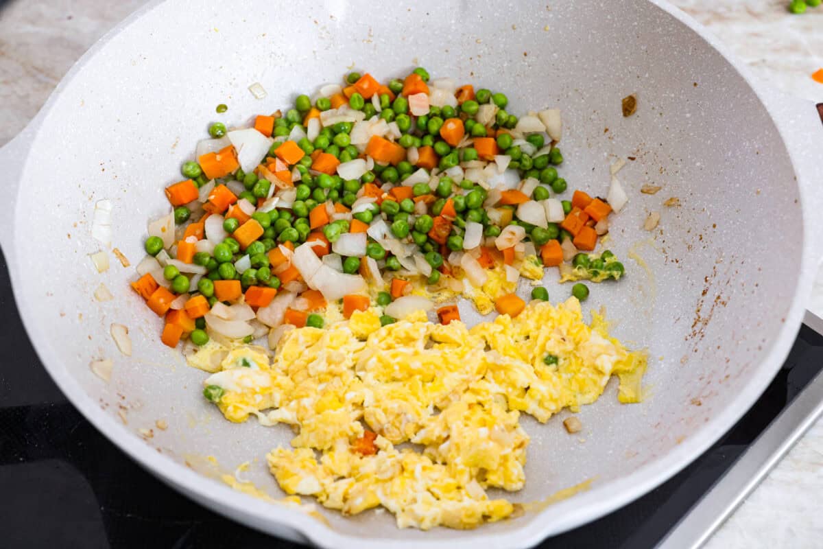 My go-to when I donโt feel like cooking? This easy chicken fried rice. I grab leftover rice and chicken, toss it all in a pan, and boom, dinner is ready in minutes. The best part? My kids devour it! Eggs being cooked and scrambled next to the cooked vegetables.