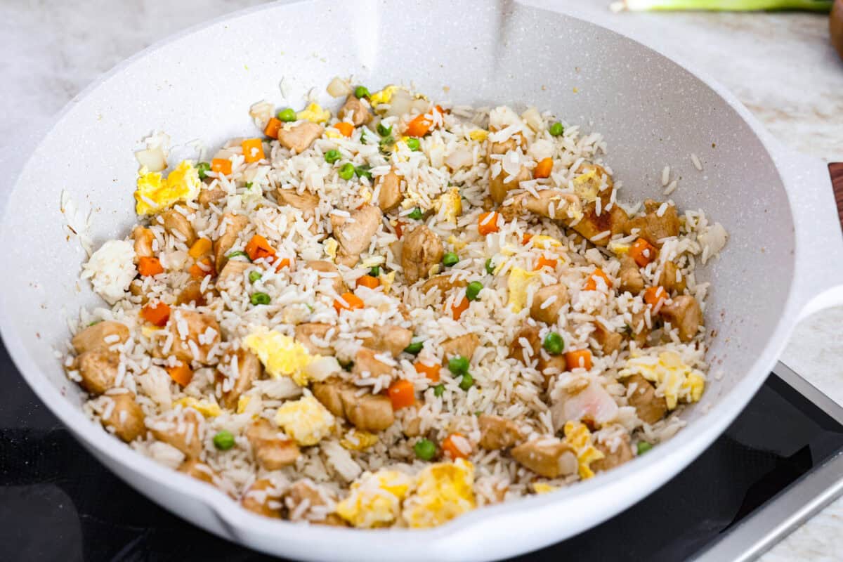 My go-to when I donโt feel like cooking? This easy chicken fried rice. I grab leftover rice and chicken, toss it all in a pan, and boom, dinner is ready in minutes. The best part? My kids devour it! Rice and chicken added to the vegetables and eggs in the skillet.