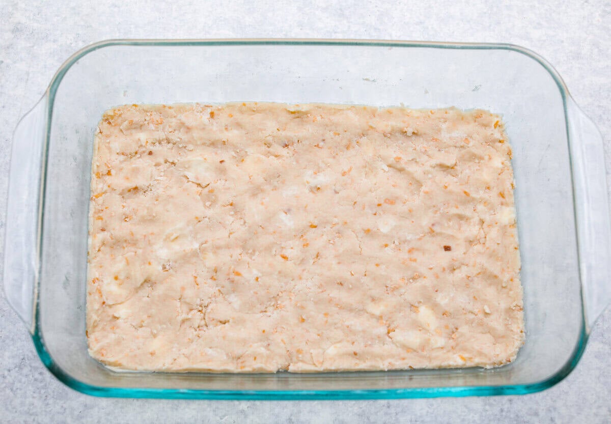My Dad LOVES coconut cream pie! When I don't have it in me to make a pie, I make this easy Coconut Lush dessert! Itโs rich, dreamy, and always the first dessert to disappear at family gatherings. crust ingredients smashed at the bottom of a baking dish.