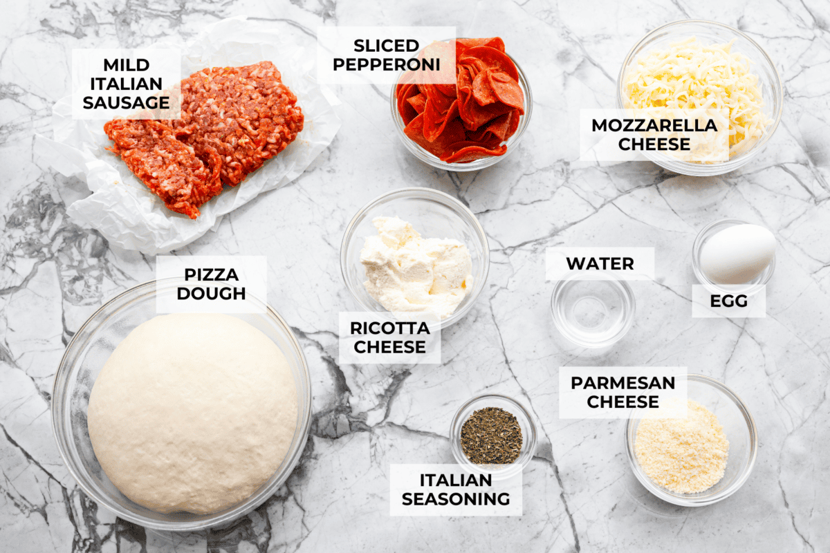 Why make calzones instead of pizza? Sometimes you just want all the pizza vibes without the mess. Calzones are like little pizza presents, warm, cheesy, and you get to make them your way! Overhead shot of labeled ingredients.