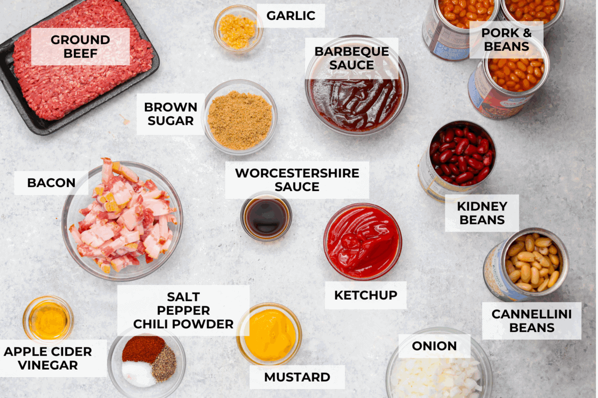 Every time I bring these cowboy beans to a summer BBQ, people start begging for the recipe, and honestly, I donโt blame them. Theyโre hearty, a little smoky, a little sweet, and always the first thing to disappear. Overhead shot of labeled ingredients.