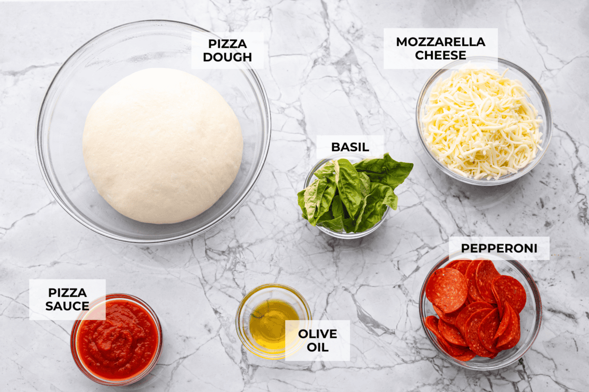 Iโm all about pizza and grilling, so when I can combine the two, itโs a win. The grill gives pizza that smoky, crispy flavor you canโt get from the oven. Trust me, this grilled pizza will have you hooked! Overhead shot of labeled ingredients.