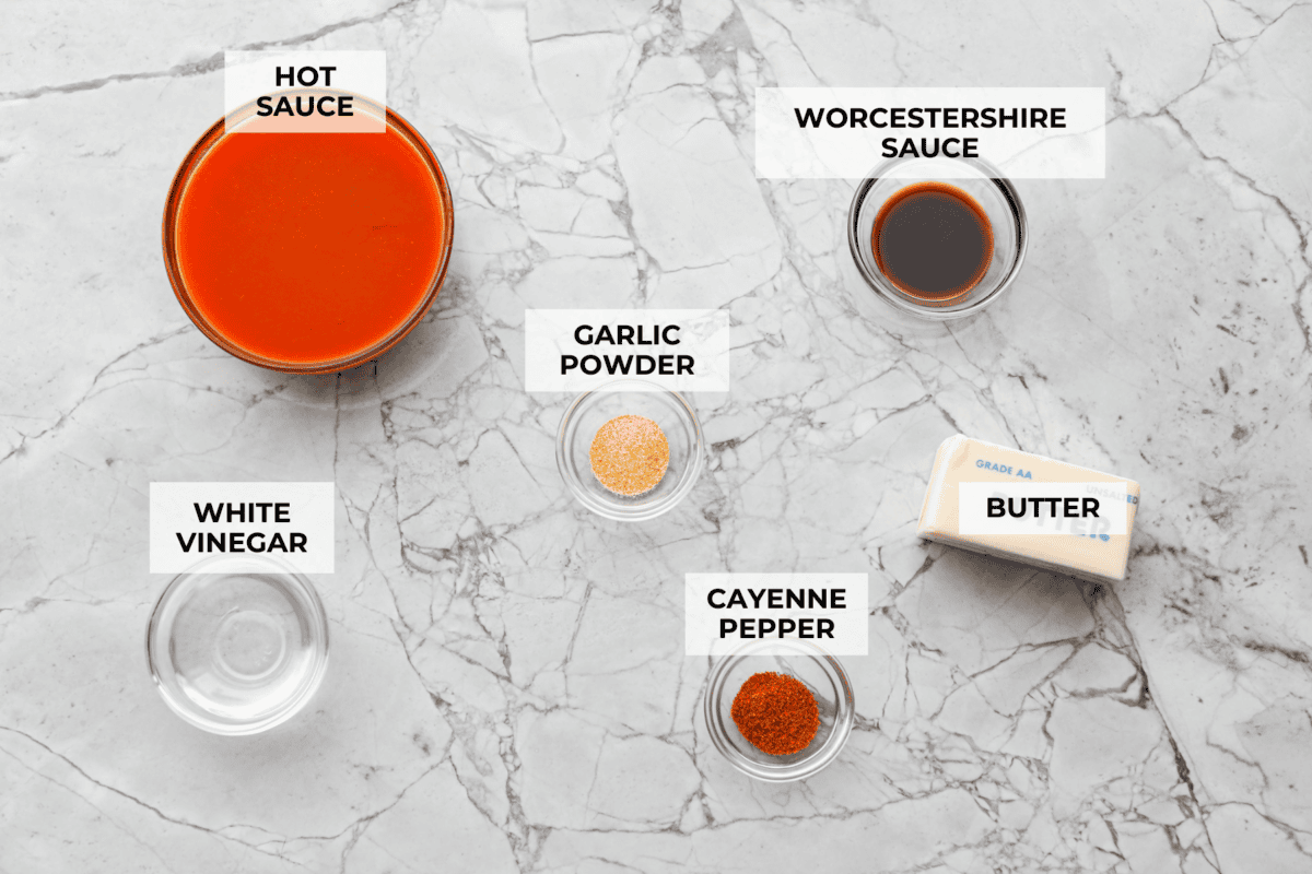 My homemade buffalo sauce is bold, tangy, and perfectly spicy! It's ready in minutes with just a few simple ingredients. Skip the store-bought stuff and make your wings, wraps, and dips next-level delicious! Overhead shot of labeled ingredients.