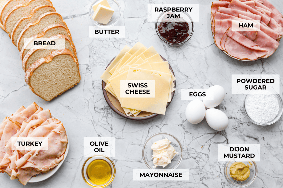 I had my first Monte Cristo sandwich at Disneyland and knew I had to recreate it at home! The melty cheese, savory ham and turkey, and golden-fried goodness deliver all the magic without the theme park ticket. Overhead shot of labeled Monte Cristo ingredients.