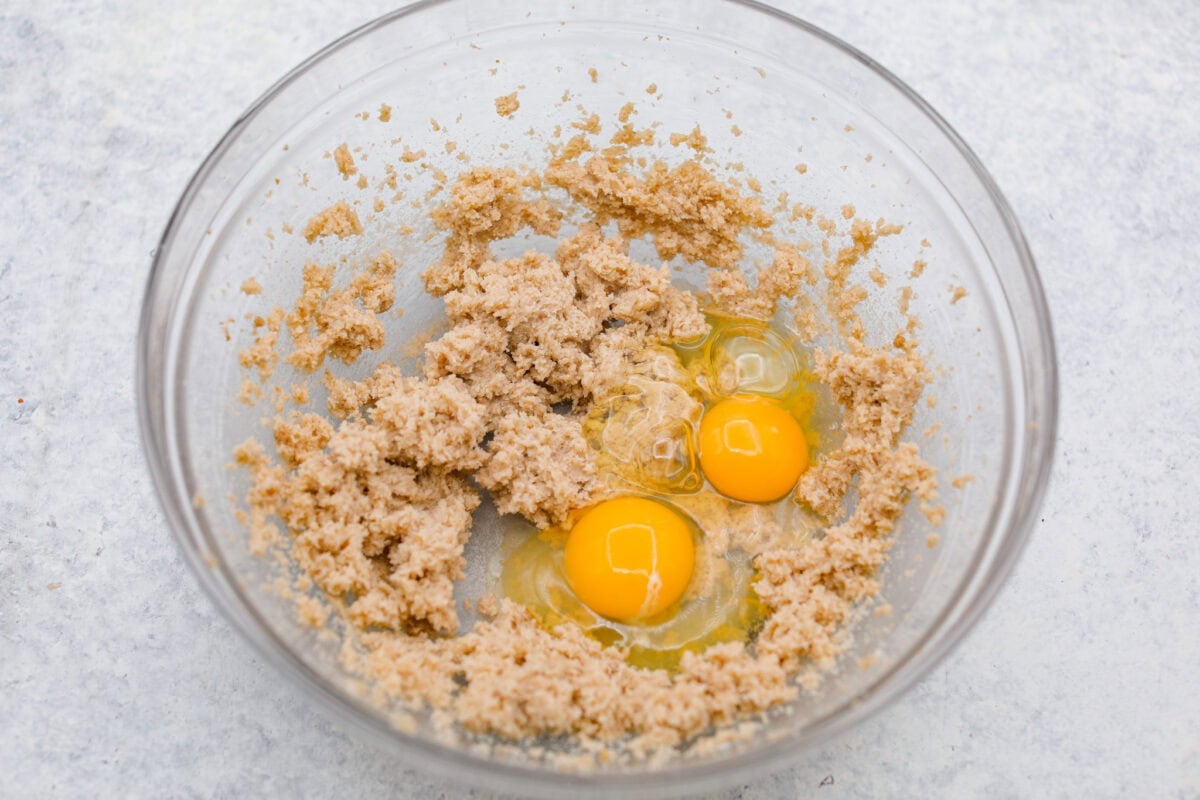 You have to make this oatmeal cake. Itโs an old-school recipe that doesnโt look like much, but that buttery pecan and coconut topping? Itโs gooey, crunchy, and totally addictive! Butter, sugar and brown sugar mixed together in a bowl with tow cracked eggs.