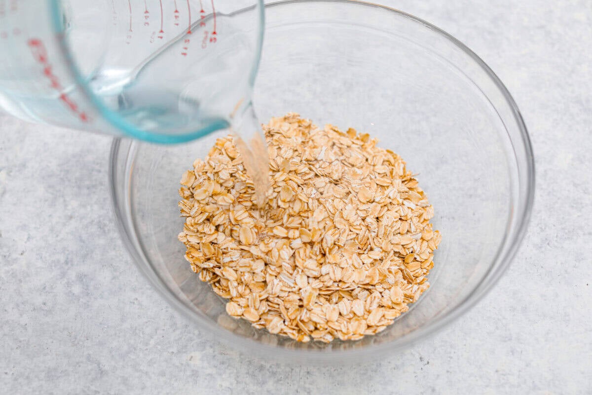 You have to make this oatmeal cake. Itโs an old-school recipe that doesnโt look like much, but that buttery pecan and coconut topping? Itโs gooey, crunchy, and totally addictive! Someone pouring boiling water onto a bowl full of old fashioned oats.