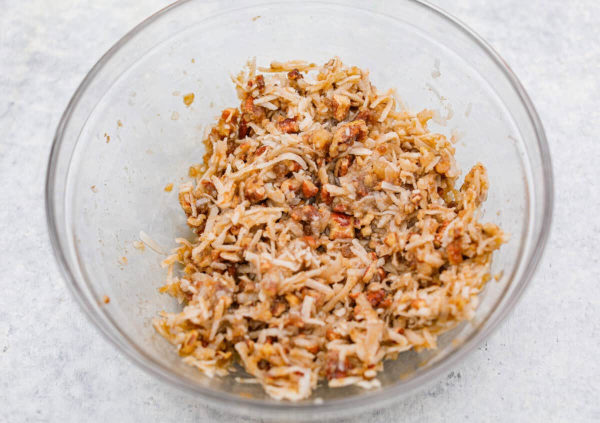 You have to make this oatmeal cake. Itโs an old-school recipe that doesnโt look like much, but that buttery pecan and coconut topping? Itโs gooey, crunchy, and totally addictive! Frosting ingredients mixed together in a bowl.