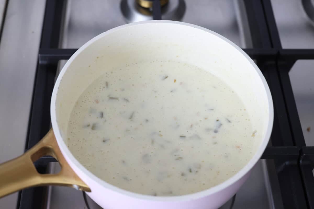 My Queso Blanco is creamy, dreamy, and seriously so addictive. The secret? White American cheese! It melts like a dream, gives you that ultra-smooth texture! Queso blanco ingredients all mixed together in a pot on the stove.