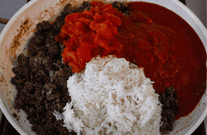 You love my cabbage rolls, and I know you guys love a casserole. So obviously, this cabbage roll casserole is the perfect match. All the delicious flavor with less work! Cooked rice, cooked beef, onion, tomatoes, tomato sauce, and seasonings in a skillet.