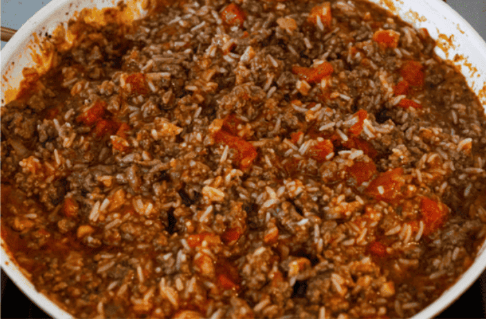 You love my cabbage rolls, and I know you guys love a casserole. So obviously, this cabbage roll casserole is the perfect match. All the delicious flavor with less work! All of the meat mixture ingredients mixed together and simmering in a skillet.